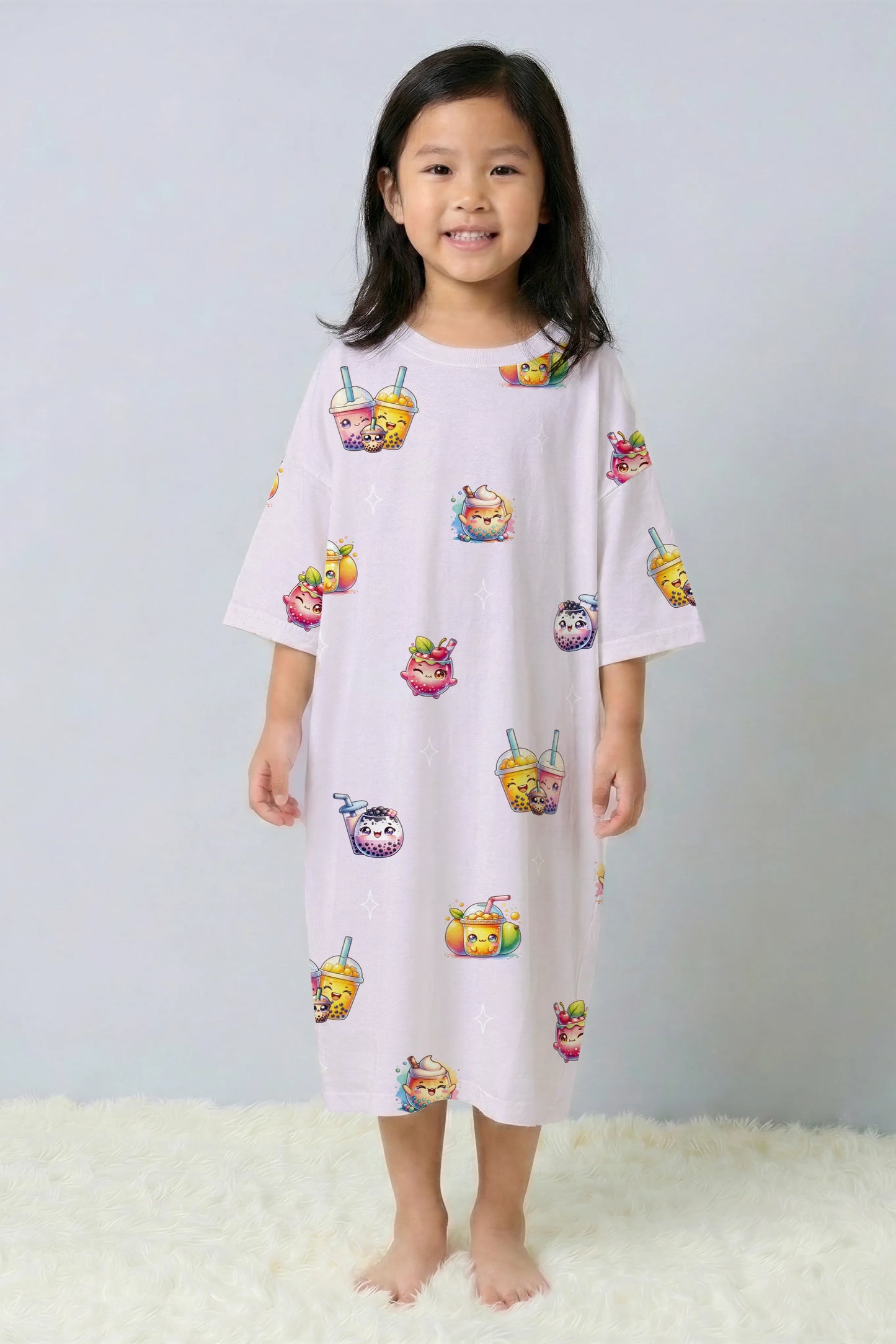 Little girl standing and smiling in a purple oversized bamboo sleep tee from the Mini Me collection. Soft and breathable kids sleepwear with a cute bubble tea print, perfect for Singapore weather.