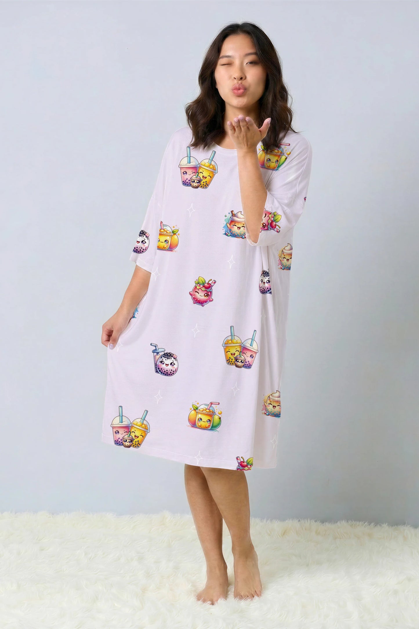 Playful model blowing a kiss while wearing a luxury oversized bamboo sleep tee. Cute and comfortable Bubble tea drink graphic nightshirt, trending sleepwear in Singapore.